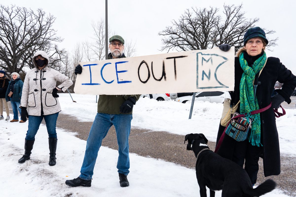 Protesters holding ICE OUT MN sign at Whipple Building