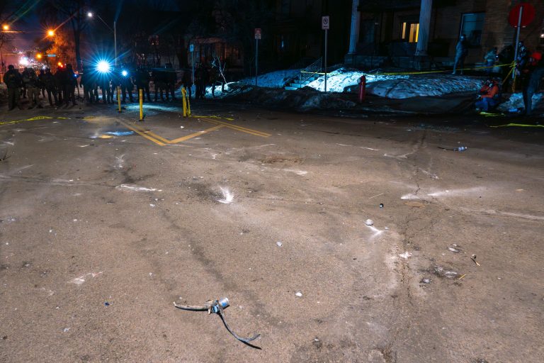 Minneapolis: Federal Officer Shoots Man Amidst ICE Operation 3 Law enforcement officers stand on a street in Minneapolis during an ICE operation, with police tape visible.