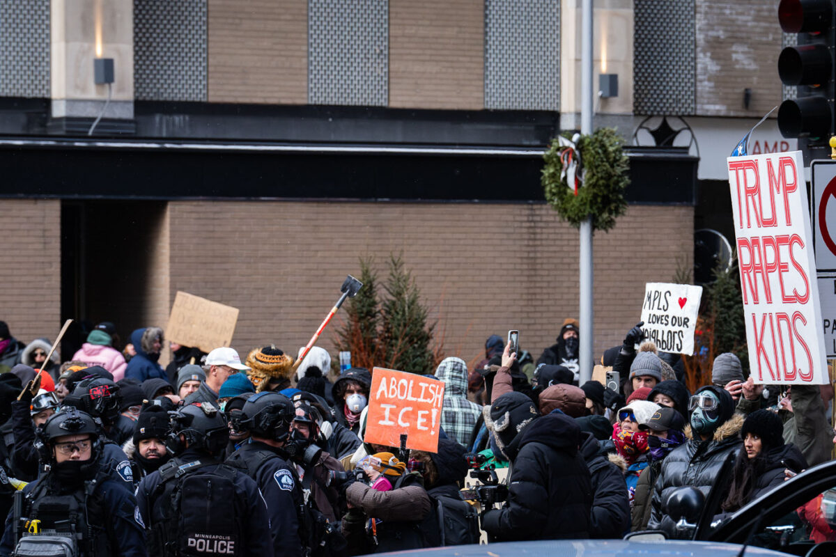 Protesters at a counter Jake Lang protest in Minneapolis holding up signs that read:TRUMP RAPES KIDSABOLISH ICE