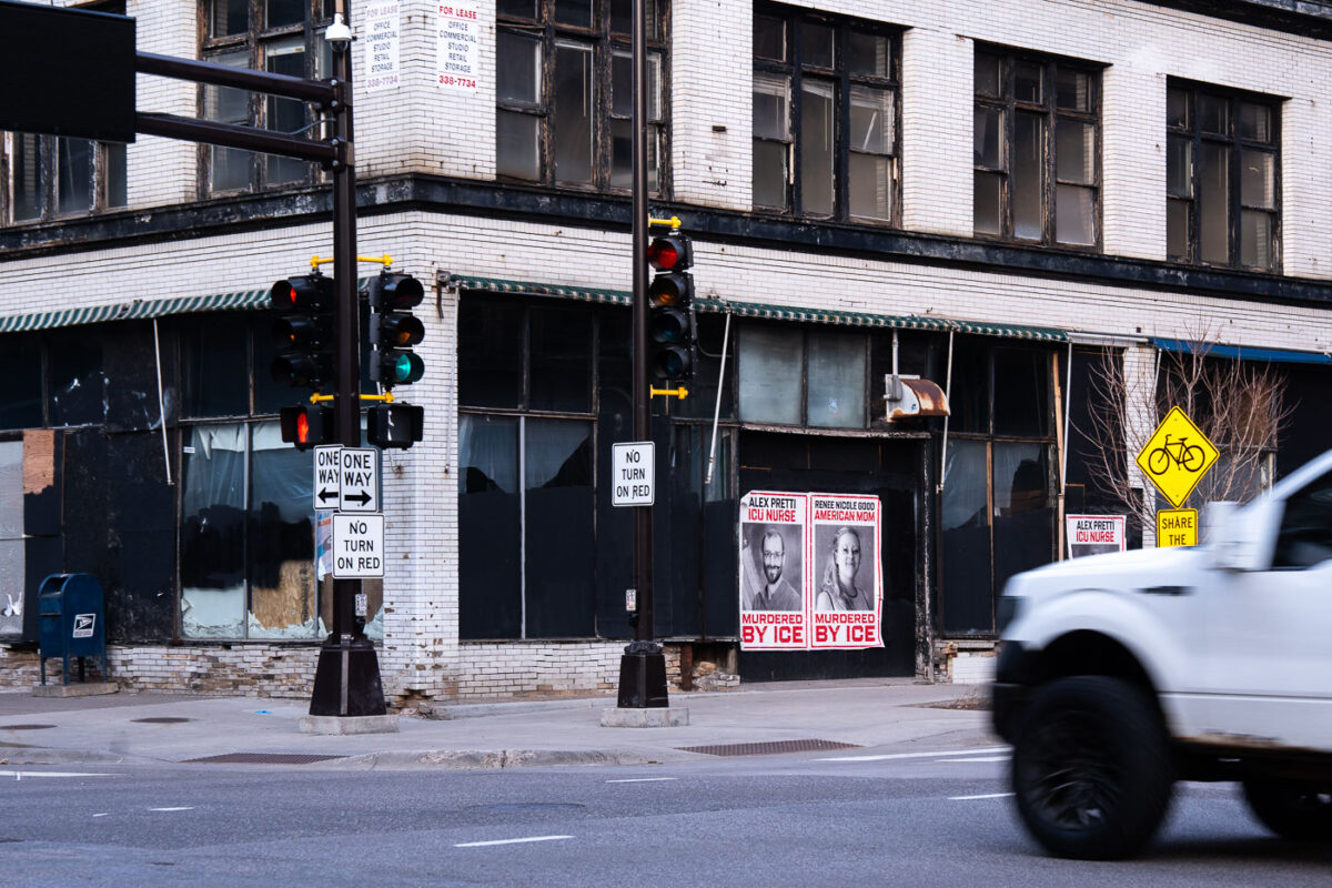 Posters protesting ICE with images of Alex Pretti and Renee Good are displayed on a building in downtown Minneapolis.
