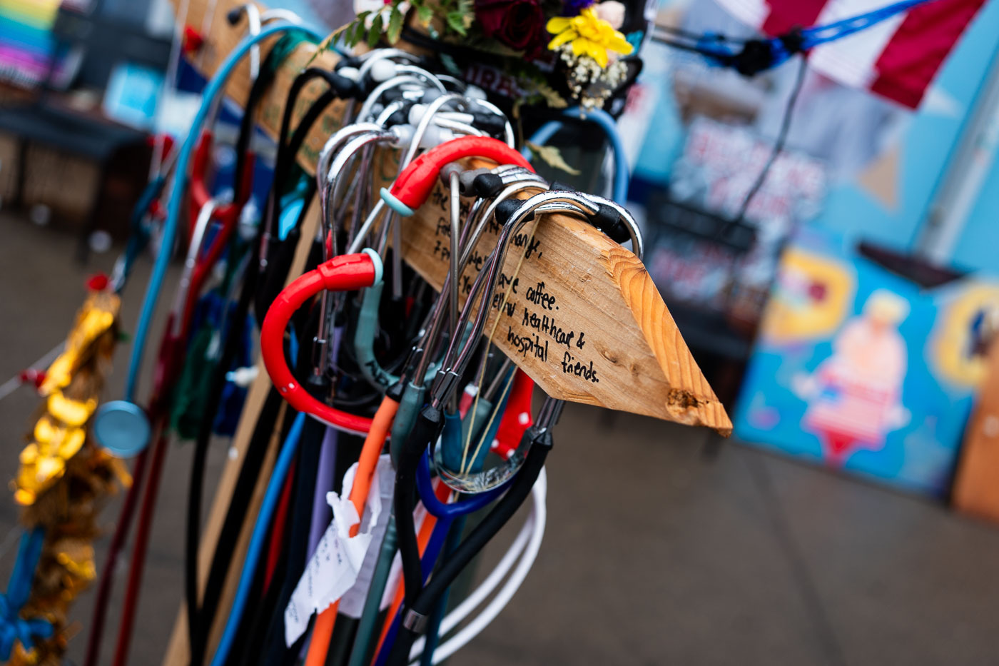 Stethoscopes and flowers at the Alex Pretti Memorial, honoring a healthcare worker who died on duty. The memorial acknowledges the risks faced by medical professionals.