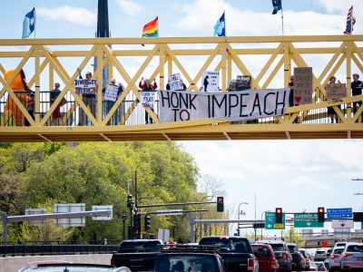 Protesters hold HONK TO IMPEACH sign in Minneapolis