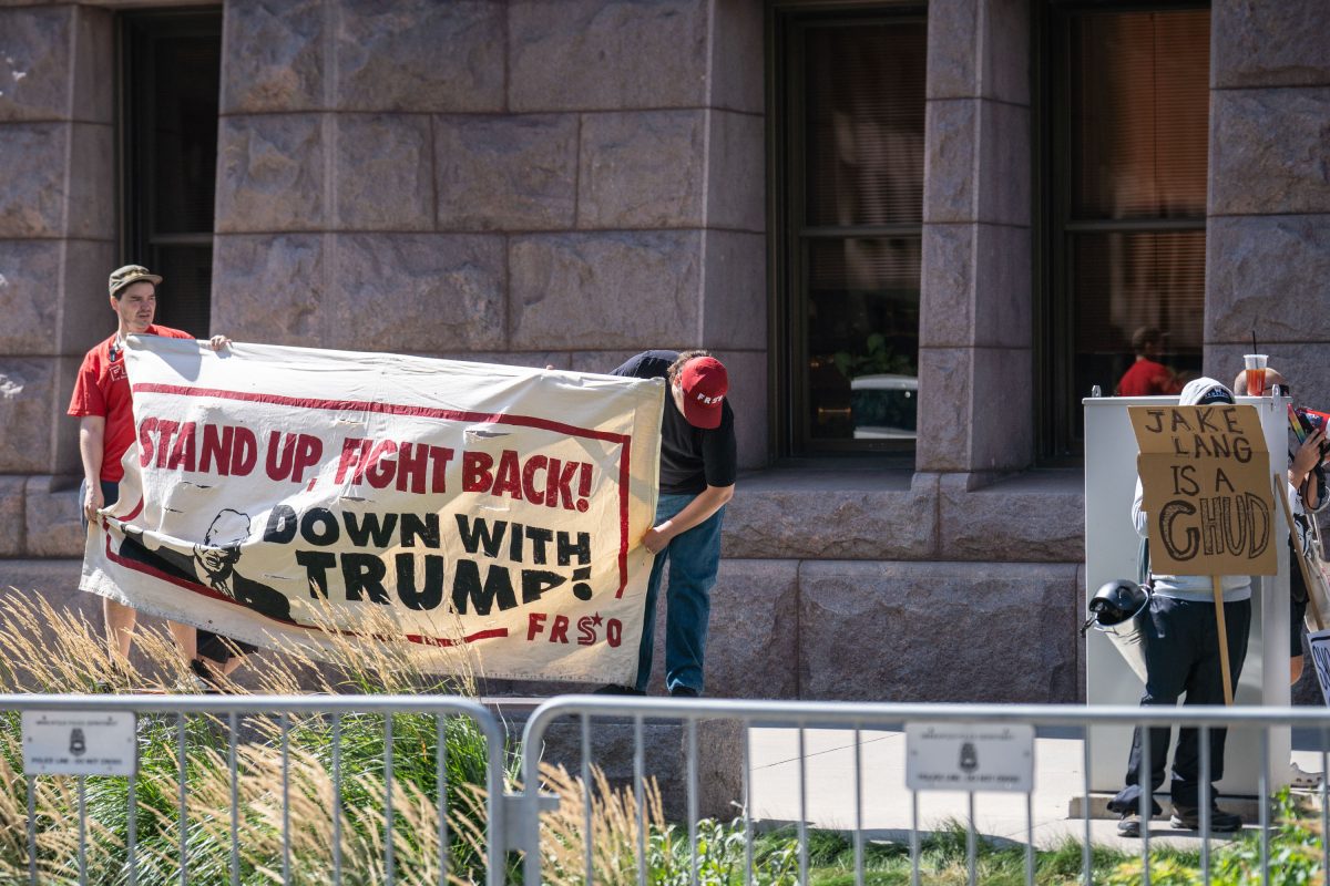 Protesters hold signs against white supremacist Jake Lang at Minneapolis City Hall.