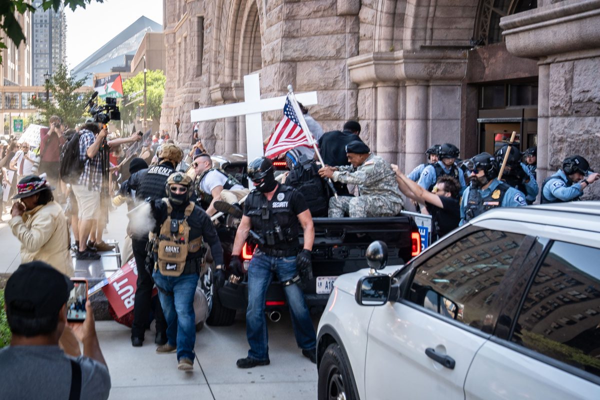 Armed security personnel and counter-protesters clash outside Minneapolis City Hall during a planned rally.