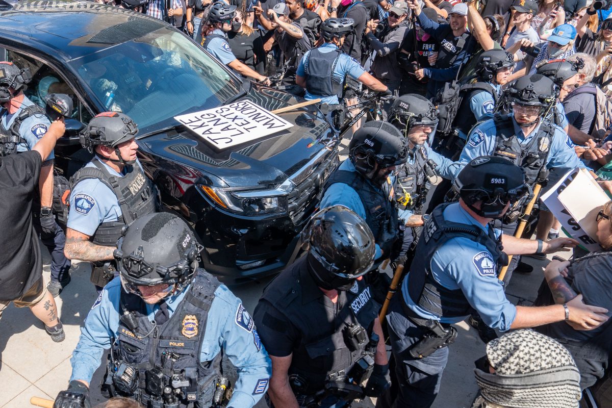 Police and counter protesters surround a vehicle during a white supremacist rally confrontation at Minneapolis City Hall.