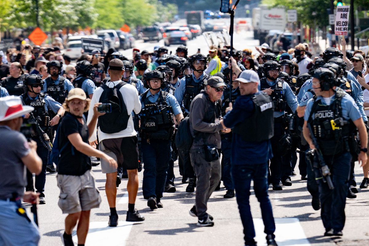 Police in riot gear monitor counter protesters gathered outside Minneapolis City Hall during a planned rally.