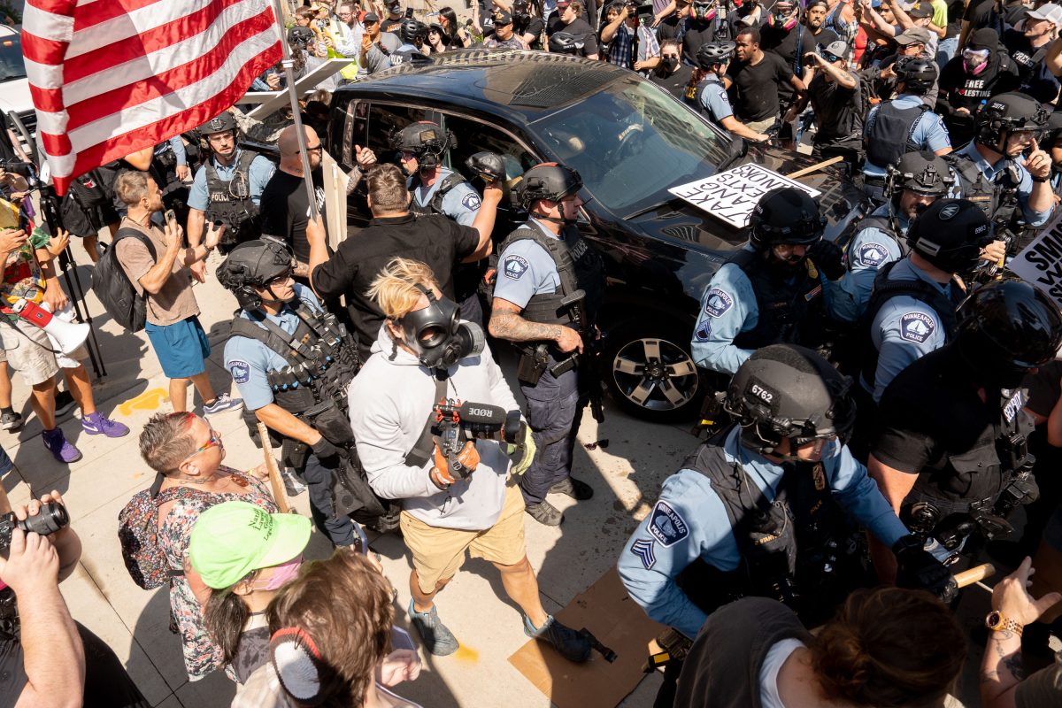 Police surround vehicle amid crowd, Jake Lang rally, Minneapolis City Hall