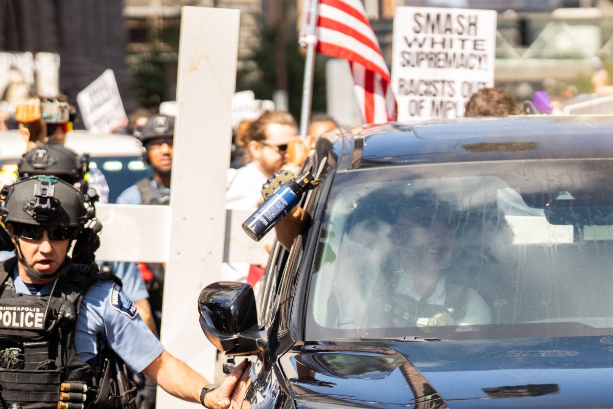 Counter-protester confronts vehicle during white supremacist rally at Minneapolis City Hall.