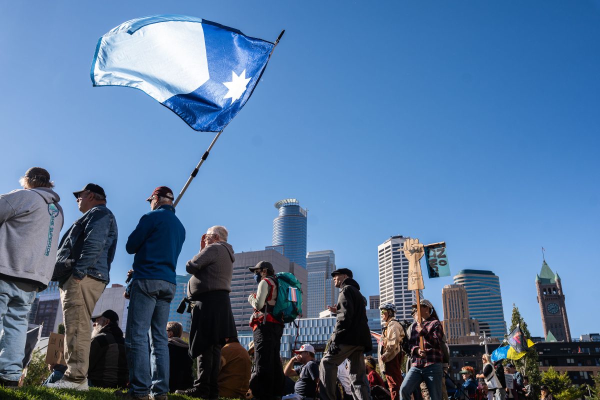 Protesters hold a Minnesota flag at a No Kings Rally in downtown Minneapolis.