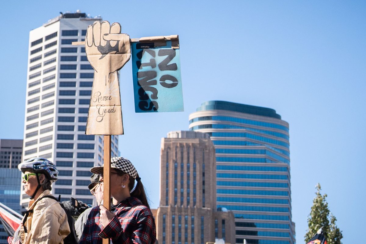 Protesters hold a raised fist sign reading "Some Good" at the No Kings rally in downtown Minneapolis.