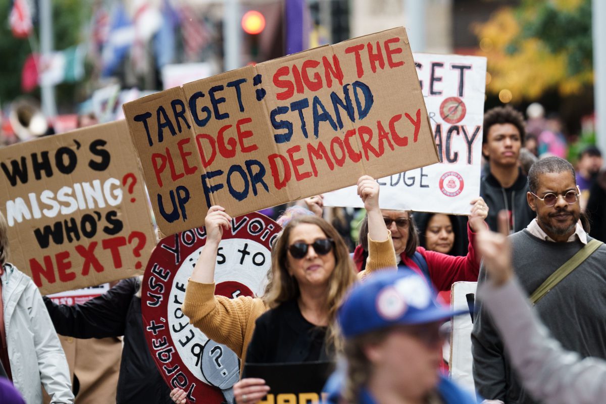 Protester with a sign asking Target to sign the Democracy Pledge