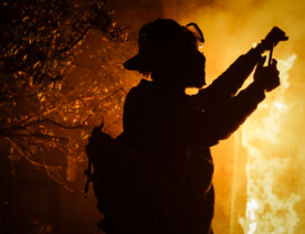 A protester holds up his first as the Minneapolis Police 3rd Precinct burns in the background. This was on the 3rd day of protests in Minneapolis following the death of George Floyd.