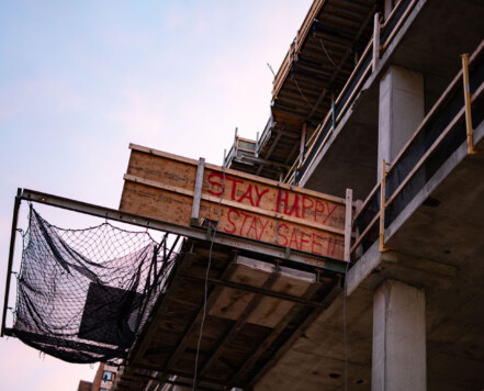 Construction site in downtown Minneapolis. Wood reads "STAY HAPPY STAY SAFE!!" Construction site in downtown Minneapolis. Wood reads "STAY HAPPY STAY SAFE!!"