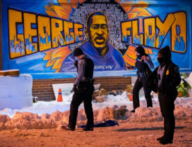 Officers look for evidence inside George Floyd Square after responding to a shooting on December 27, 2020.