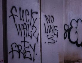 "Fuck Walz + Frey" "No Line 3" written under a bridge on the Midtown Greenway.