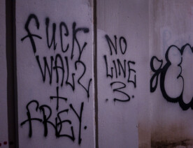 "Fuck Walz + Frey" "No Line 3" written under a bridge on the Midtown Greenway.