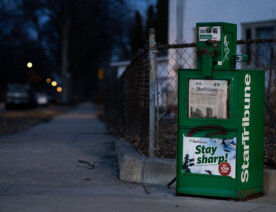 A news rack in South Minneapolis. Star Tribune headline "They must pick: Cop or doctor?"