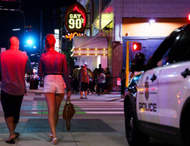 People walking across the street near the Gay 90s Nightclub on Hennepin Avenue in Downtown Minneapolis in July 2023.