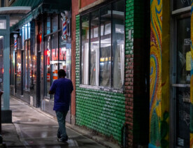 A man walking on the sidewalk down Lake Street in South Minneapolis.