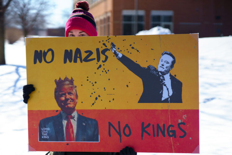Protester holds a sign up that reads "No Nazis No Kings" at a "Tesla Takedown" protest in front of a Tesla facility in Minneapolis on February 22, 2025. Protester holds a sign up that reads "No Nazis No Kings" at a "Tesla Takedown" protest in front of a Tesla facility in Minneapolis on February 22, 2025.