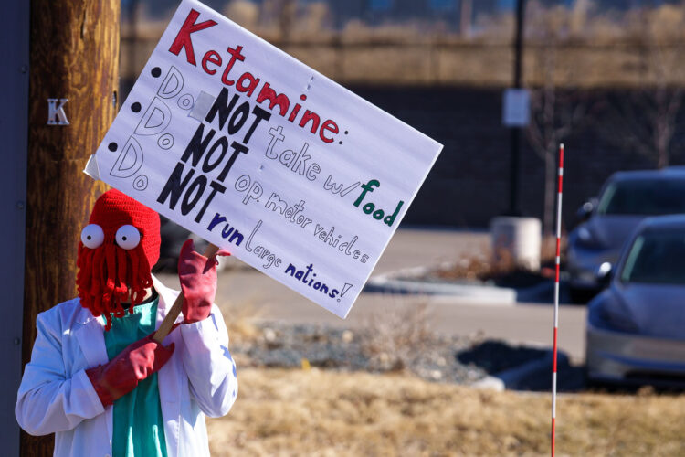 Protester in Minneapolis (Golden Valley) holds up a protest sign at a Tesla facility. Protester in Minneapolis (Golden Valley) holds up a protest sign at a Tesla facility.