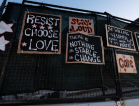 Signs hanging from the fencing around the burned Minneapolis police station.Resist Choose LoveStay LoudThere Is Nothing As Stable As ChangeBe Willing To Listen Even When It's HardCare
