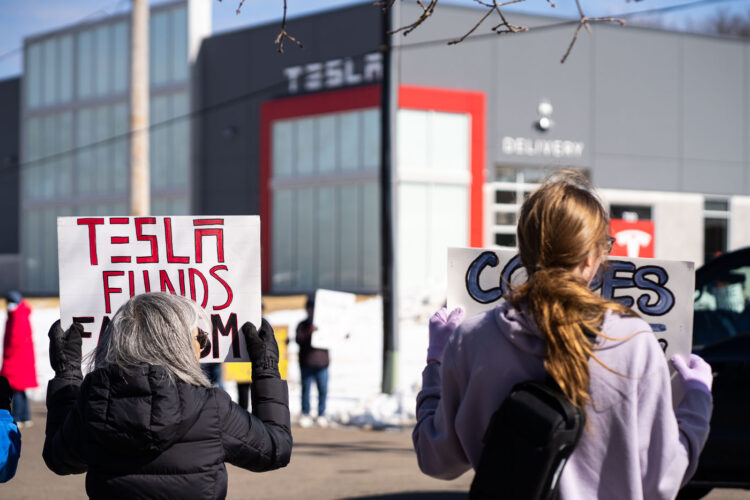 Protesters hold signs outside a Tesla showroom in Golden Valley(Minneapolis) on March 8,2025. Protesters hold signs outside a Tesla showroom in Golden Valley(Minneapolis) on March 8,2025.
